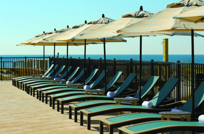 Telescope Casual outdoor lounge chairs and umbrellas on a rooftop terrace